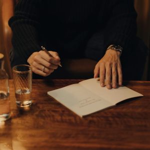 Person in Black Long Sleeve Shirt Holding White Paper