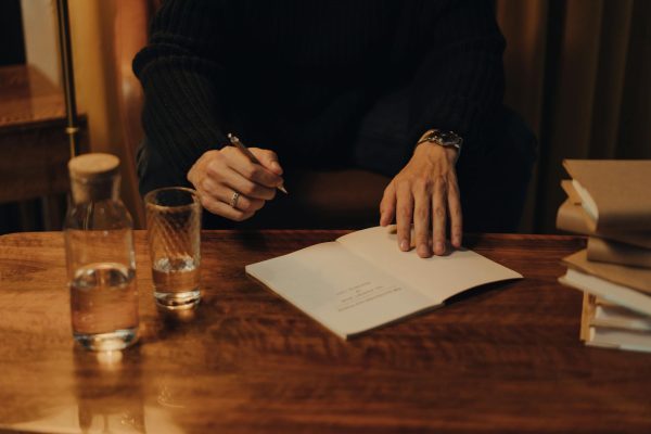 Person in Black Long Sleeve Shirt Holding White Paper